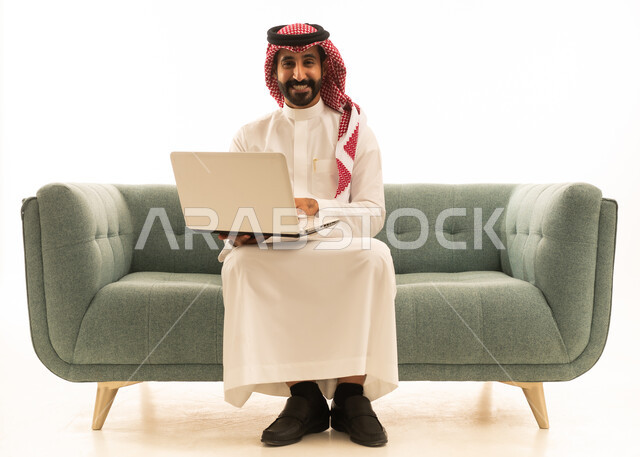 Saudi Man Using Laptop on Green Sofa White Background