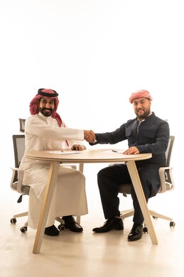 مصافحة رجل أعمال سعودي وكردي على خلفية بيضاء