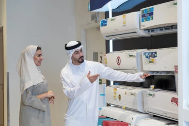 زوجان عربيان يتسوقان لشراء مكيف هواء في متجر أجهزة