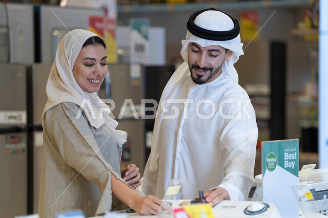 زوج إماراتي يتسوق لشراء أجهزة منزلية في متجر