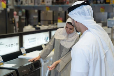 زوجين إماراتيين يتسوقان لشراء غسالة ملابس في متجر