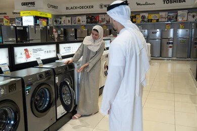 زوجان إماراتيان يتسوقان لشراء غسالة ملابس في معرض