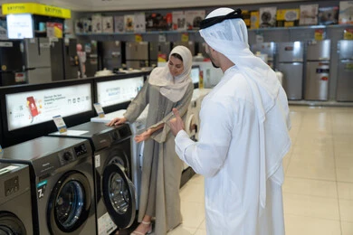 زوجان إماراتيان يتسوقان لشراء غسالة ملابس في متجر