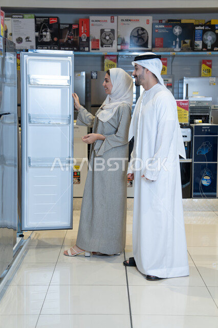 زوجان إماراتيان يتسوقان لشراء ثلاجة في معرض أجهزة منزلية