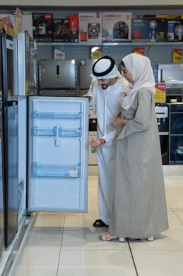 زوجان إماراتيان يتسوقان لشراء ثلاجة في متجر إلكترونيات