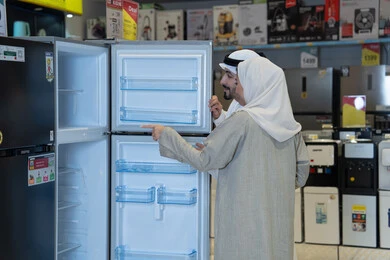 زوجان إماراتيان يتسوقان لشراء ثلاجة في متجر إلكترونيات