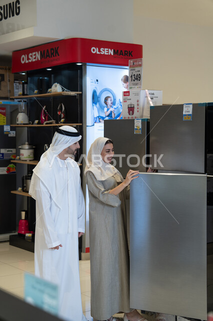 زوج إماراتي يتسوقان لشراء ثلاجة في متجر أجهزة
