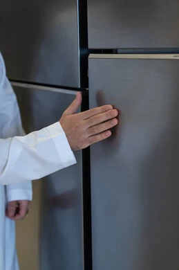 رجل سعودي بالثوب يلمس ثلاجة حديثة