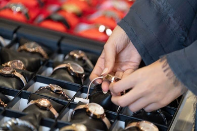 امرأة عربية تختار ساعة يد ذهبية في متجر مجوهرات