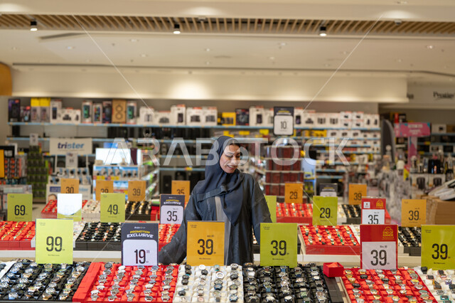 امرأة سعودية بالعباءة في متجر ساعات