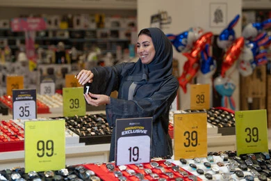 امرأة سعودية بالعباءة تتسوق في متجر ساعات