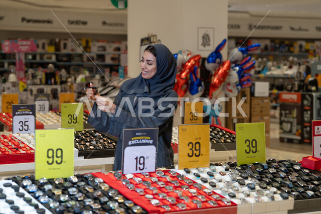 امرأة سعودية تتسوق لشراء ساعة يد في متجر