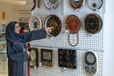 امرأة سعودية تتسوق لشراء ساعات حائط في متجر
