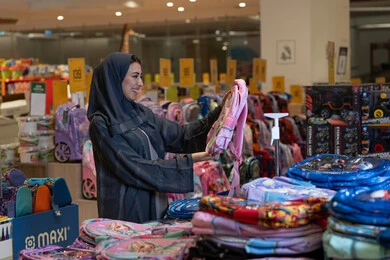 امرأة سعودية تتسوق حقائب مدرسية في متجر تجاري