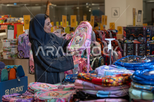 امرأة سعودية تتسوق لشراء حقيبة مدرسية في المتجر