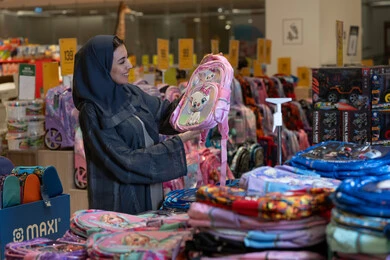 امرأة سعودية تتسوق لشراء حقيبة مدرسية في المتجر