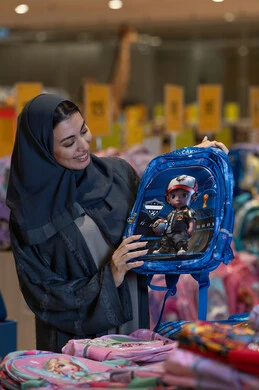 امرأة سعودية تتسوق لشراء حقيبة مدرسية في متجر