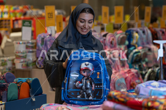 امرأة سعودية تتسوق لشراء حقيبة مدرسية في المتجر