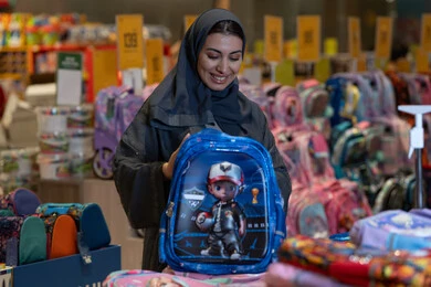 امرأة سعودية تتسوق لشراء حقيبة مدرسية في المتجر