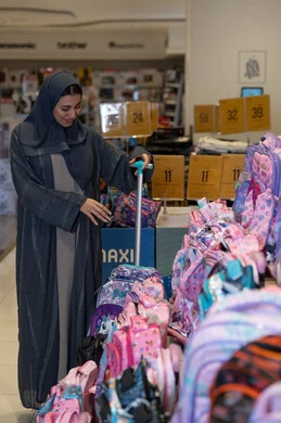 امرأة سعودية تتسوق للحقائب المدرسية في متجر تجزئة