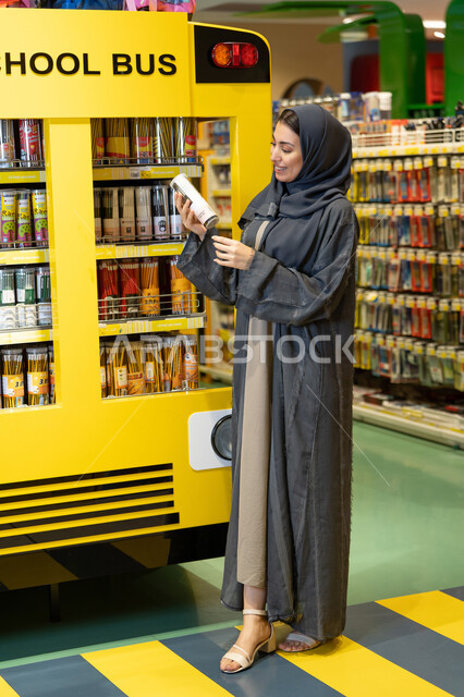 امرأة سعودية بالعباءة تتسوق في متجر أدوات مدرسية