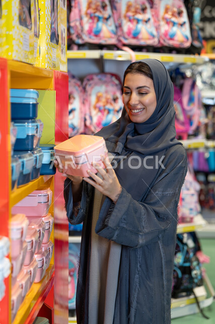 امرأة سعودية بالعباءة تتسوق للمستلزمات المدرسية