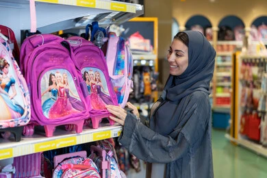 امرأة سعودية تتسوق لشراء حقائب مدرسية في المتجر