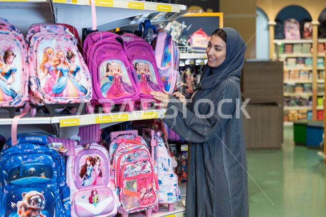 امرأة سعودية تتسوق لشراء حقائب مدرسية في المتجر