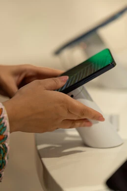 Emirati Woman Examining Smartphone in Retail Store