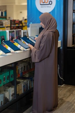 Saudi Woman Browsing Tablets in Electronics Store