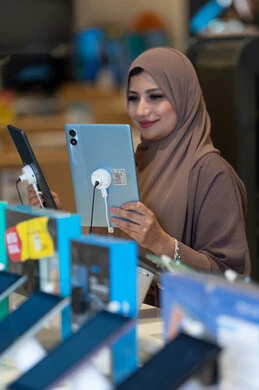 امرأة سعودية تتسوق لشراء جهاز لوحي في متجر
