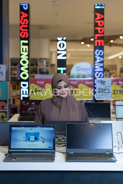امرأة إماراتية بالحجاب تتسوق أجهزة كمبيوتر