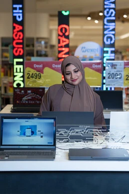 امرأة سعودية تتسوق أجهزة لابتوب في متجر إلكترونيات