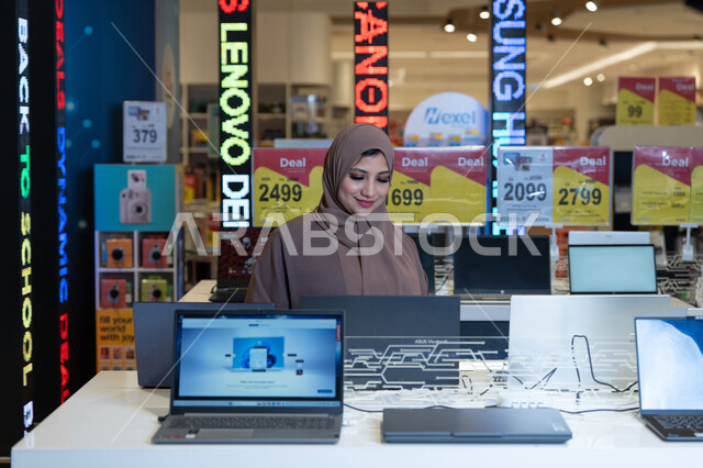 امرأة سعودية تتسوق أجهزة كمبيوتر في متجر إلكترونيات