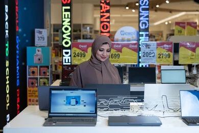 امرأة سعودية تتسوق أجهزة كمبيوتر في متجر إلكترونيات
