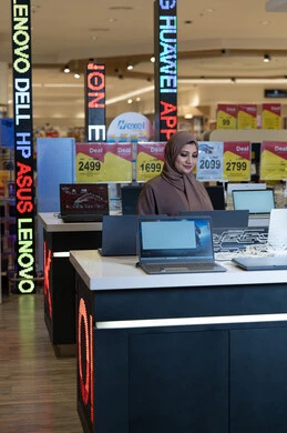 امرأة سعودية تتسوق لشراء أجهزة لابتوب في متجر إلكترونيات