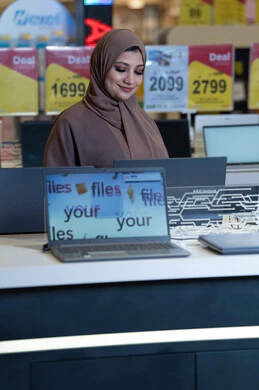امرأة سعودية تتسوق لشراء لابتوب في متجر إلكترونيات