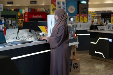 Arab Woman in Abaya Using Laptop in Electronics Store