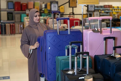امرأة سعودية تتسوق حقائب السفر في متجر تجزئة