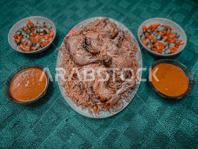 Popular rice dish with Madhbi chicken prepared in the kitchen with vegetable salad, Gulf Arab food, traditional Saudi dish