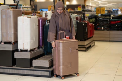 Arab Woman Shopping for Luggage in Retail Store