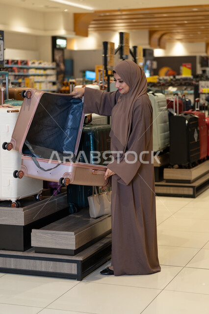 Arab Woman Shopping for Suitcase in Luggage Store