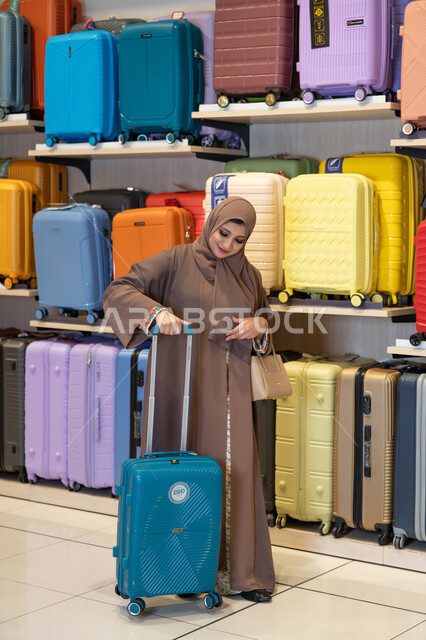 Arab Woman in Abaya Shopping for Suitcase in Store