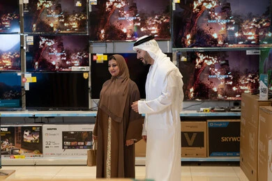 Emirati Couple Shopping for Smart TVs in Electronics Store