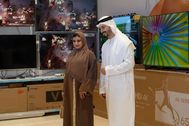 زوجان إماراتيان يتسوقان لشراء أجهزة التلفاز في متجر إلكترونيات