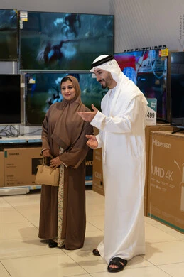 زوجان إماراتيان يتسوقان لشراء التلفزيونات في متجر إلكترونيات