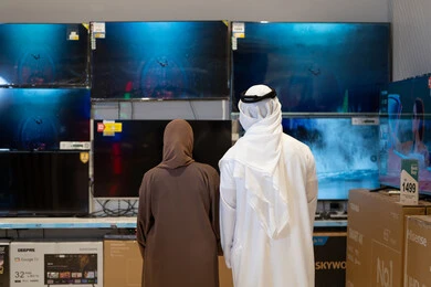 زوجان إماراتيان يتسوقان أجهزة التلفاز في متجر إلكترونيات