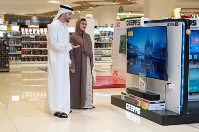 Emirati Couple Shopping for Television in Electronics Store