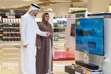 زوجان إماراتيان يتسوقان لشراء تلفزيون في متجر إلكترونيات