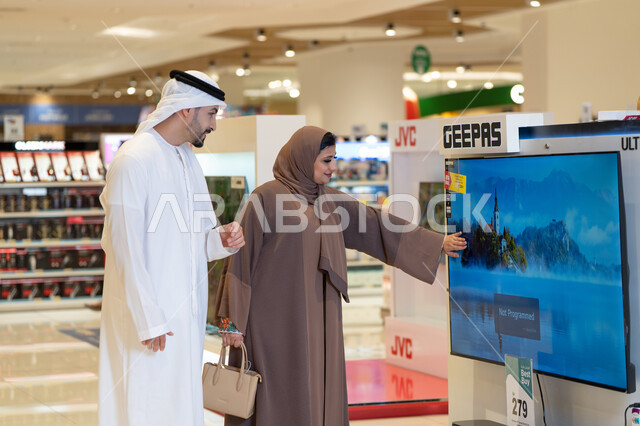 زوجان إماراتيان يتسوقان لشراء الإلكترونيات في مول حديث